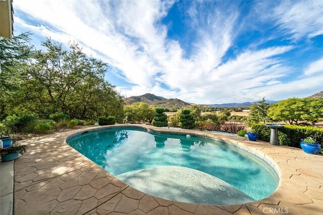 view of swimming pool featuring a patio area and a mountain view