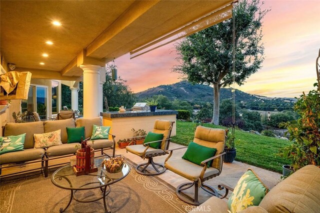 patio terrace at dusk featuring outdoor lounge area and a mountain view