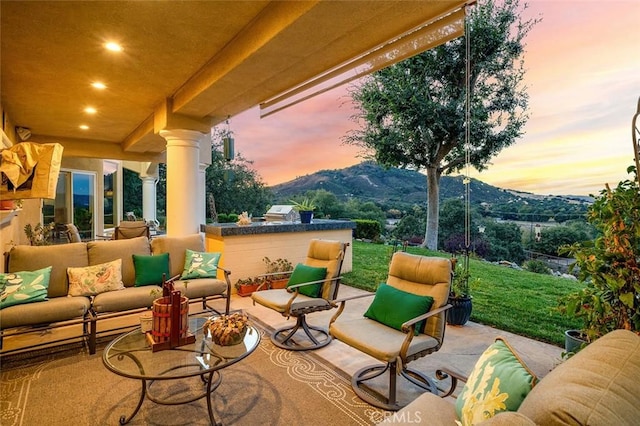 patio terrace at dusk featuring a mountain view and outdoor lounge area