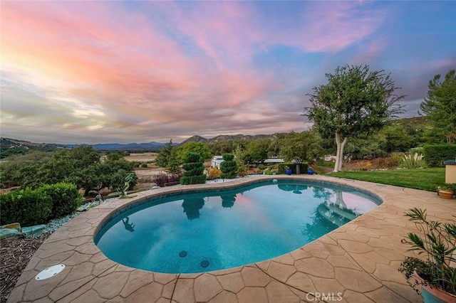 outdoor pool featuring a patio area and a mountain view