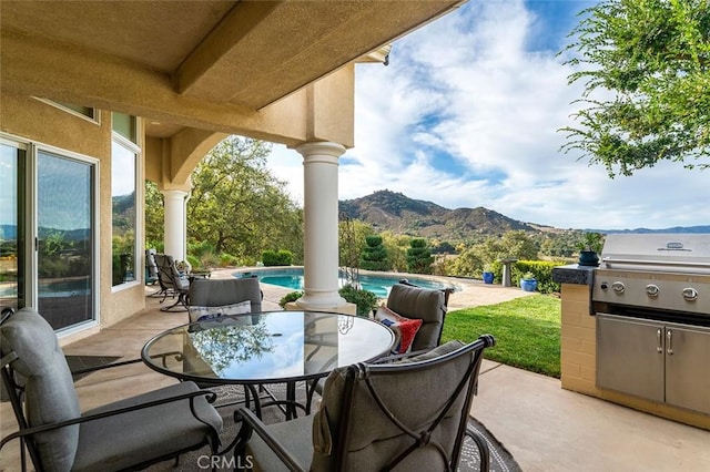 view of patio / terrace with an outdoor pool, a mountain view, and outdoor dining area