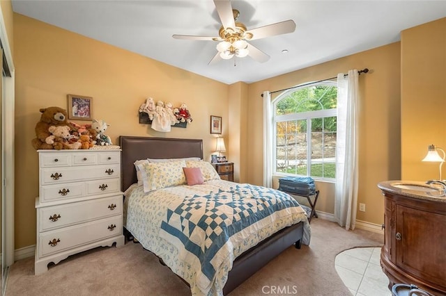 bedroom with light carpet, ceiling fan, and baseboards