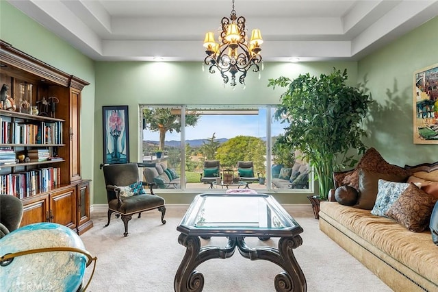 sitting room featuring light colored carpet, a raised ceiling, and a notable chandelier