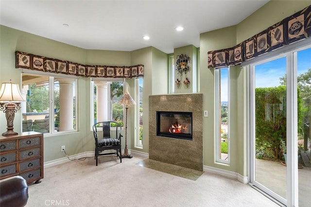 living area featuring recessed lighting, a fireplace with flush hearth, carpet, and baseboards