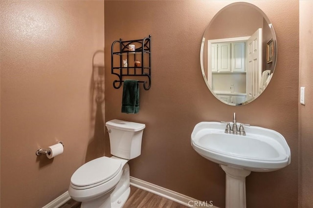 bathroom with hardwood / wood-style floors and toilet