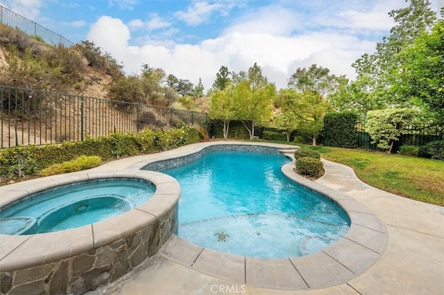 view of swimming pool featuring a lawn and an in ground hot tub