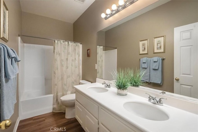 full bathroom with vanity, hardwood / wood-style floors, shower / tub combo, and toilet