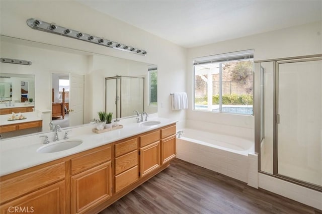 bathroom featuring vanity, hardwood / wood-style flooring, and plus walk in shower