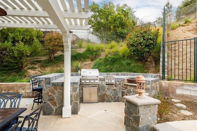 view of patio / terrace featuring a pergola, area for grilling, and exterior bar