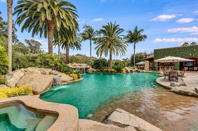 view of swimming pool with pool water feature and a patio area