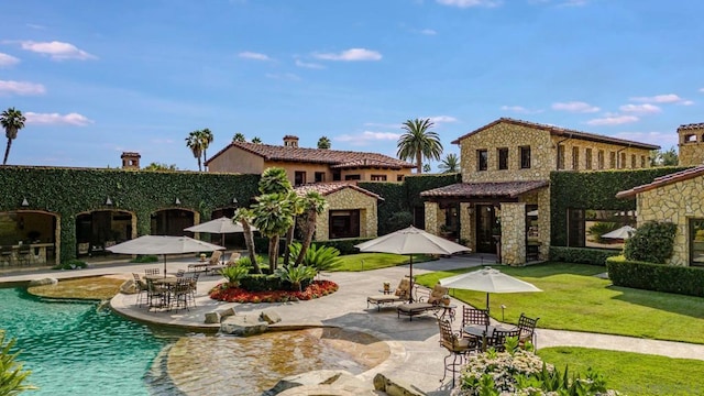 view of property's community featuring a yard, a swimming pool, and a patio