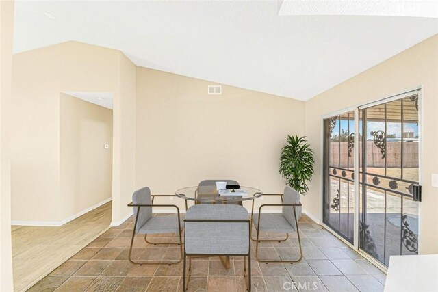 dining room with hardwood / wood-style flooring and lofted ceiling