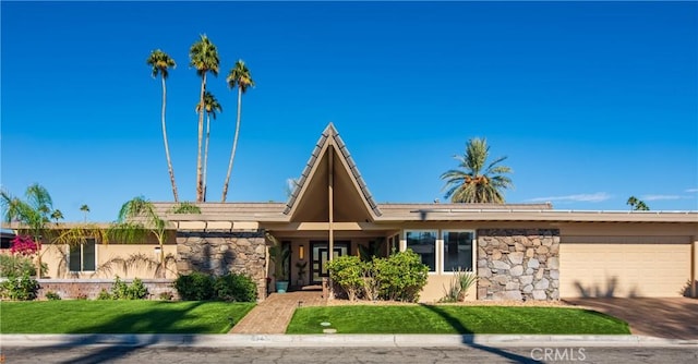 view of front of property with a garage and a front lawn