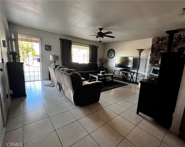 15353 El Centro Rd, Hesperia, CA 92345 - living area featuring a ceiling fan, light tile patterned flooring, a wood stove, and a textured ceiling