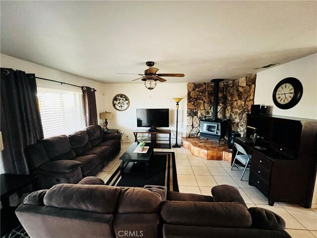 15353 El Centro Rd, Hesperia, CA 92345 - living room featuring light tile patterned floors, a ceiling fan, and a wood stove