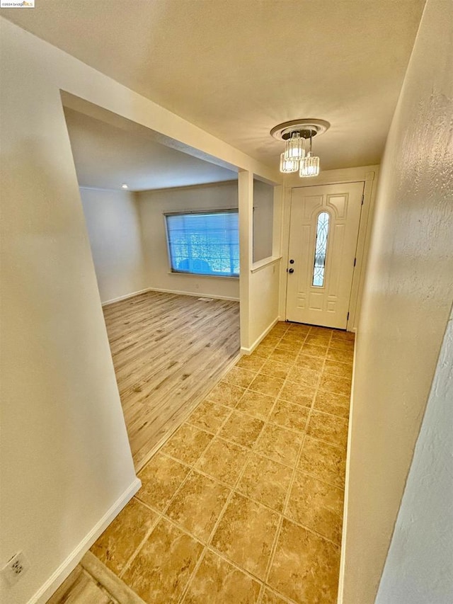 foyer featuring wood-type flooring and a notable chandelier