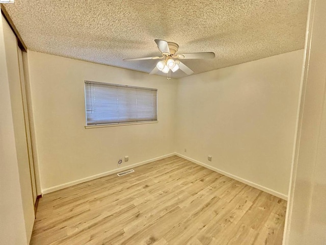 spare room featuring ceiling fan, a textured ceiling, and light wood-type flooring