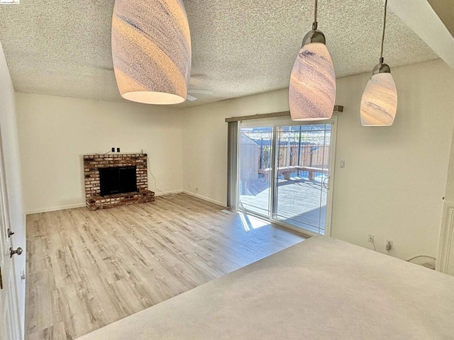 living room with hardwood / wood-style flooring, a fireplace, and a textured ceiling