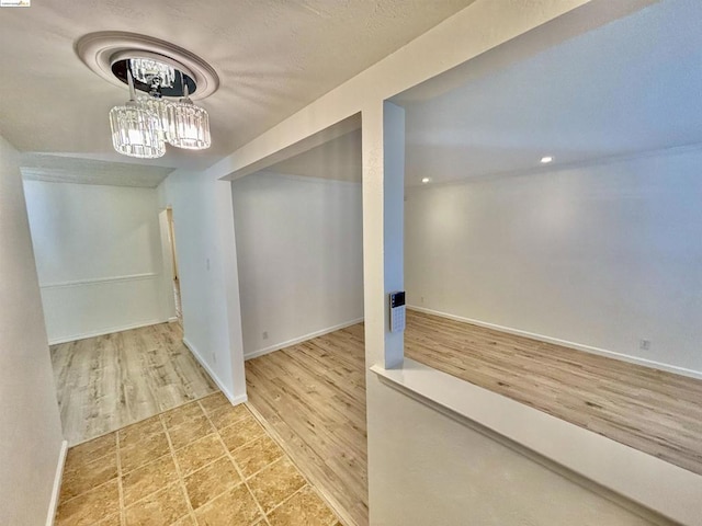 basement with hardwood / wood-style flooring and an inviting chandelier