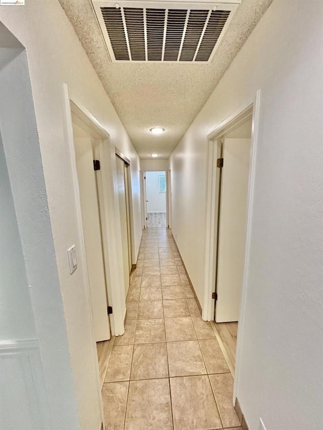 hall featuring light tile patterned flooring