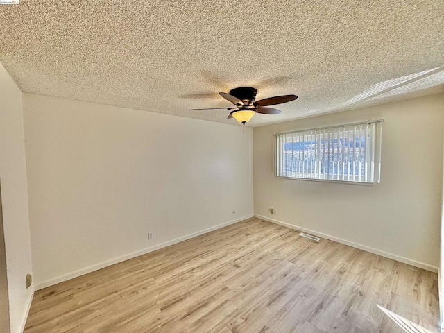 unfurnished room featuring ceiling fan, light hardwood / wood-style floors, and a textured ceiling