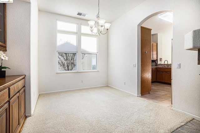 carpeted dining space with sink and a notable chandelier