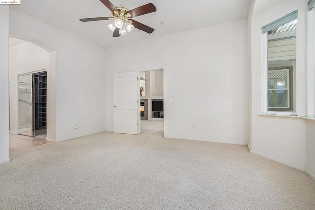 unfurnished room featuring ceiling fan and light carpet