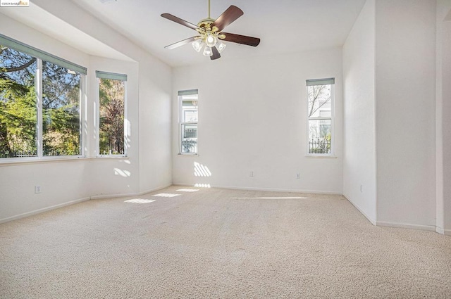 unfurnished room with light carpet, ceiling fan, and a healthy amount of sunlight