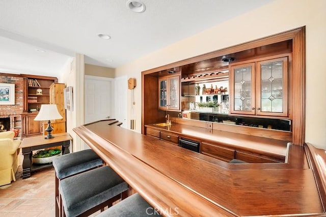 bar featuring a brick fireplace and sink