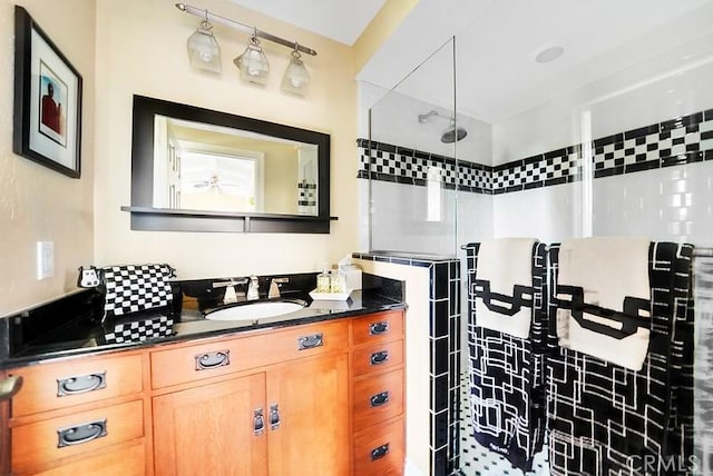 bathroom with a tile shower and vanity