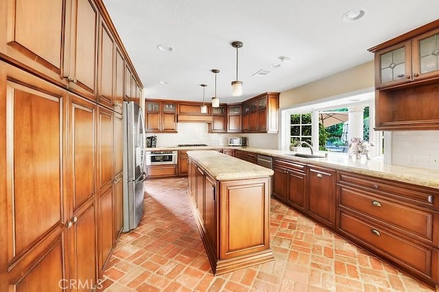 kitchen featuring decorative backsplash, a center island, stainless steel appliances, and sink