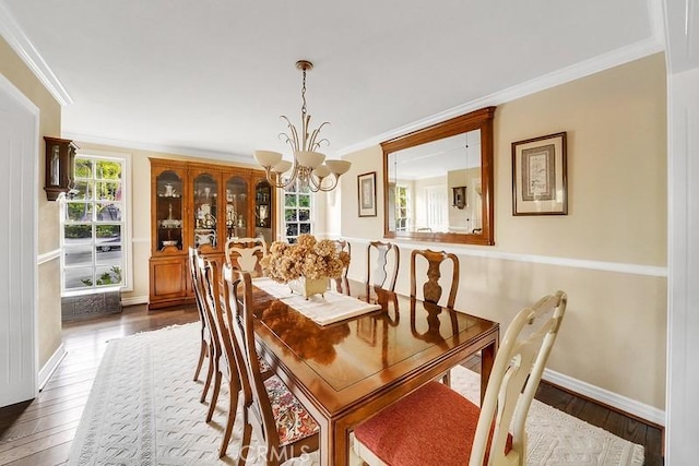 dining room featuring crown molding, wood-type flooring, and a notable chandelier