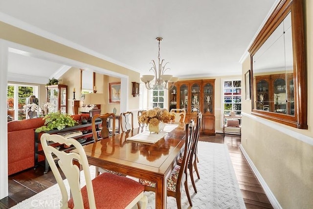 dining area with ornamental molding, an inviting chandelier, and dark wood-type flooring