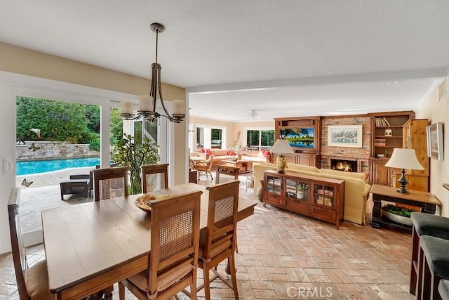 dining area featuring a notable chandelier and a fireplace