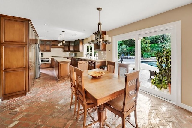 dining area with a notable chandelier, plenty of natural light, and sink