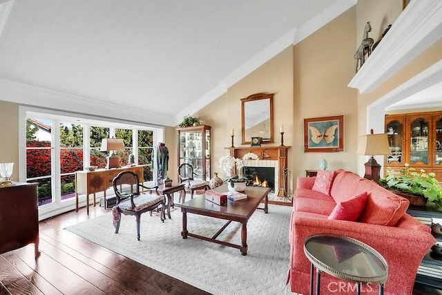 living room with a fireplace, crown molding, hardwood / wood-style floors, and high vaulted ceiling