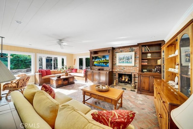 living room featuring ceiling fan, a fireplace, and ornamental molding