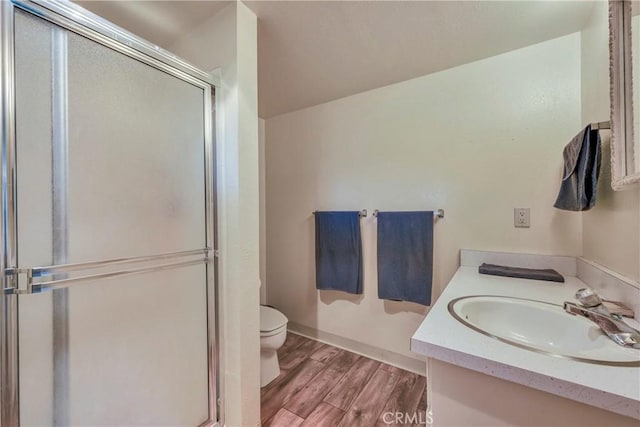 bathroom featuring hardwood / wood-style flooring, vanity, toilet, and an enclosed shower