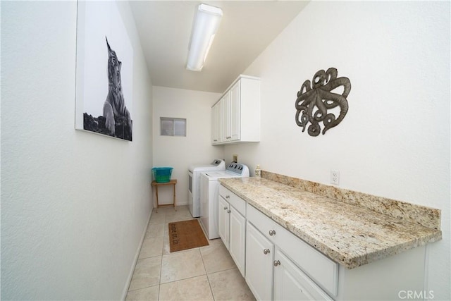 washroom with cabinets, light tile patterned floors, and washing machine and clothes dryer