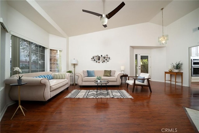 living room with ceiling fan with notable chandelier, high vaulted ceiling, and dark hardwood / wood-style floors