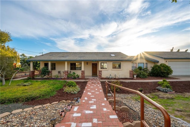 ranch-style house featuring a garage and covered porch