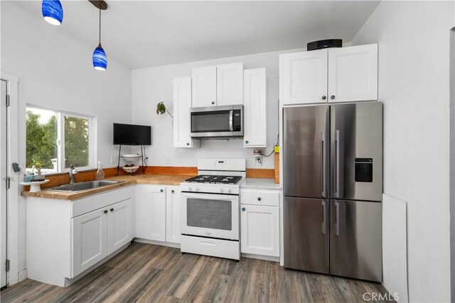 kitchen featuring pendant lighting, dark wood-type flooring, sink, white cabinetry, and stainless steel appliances