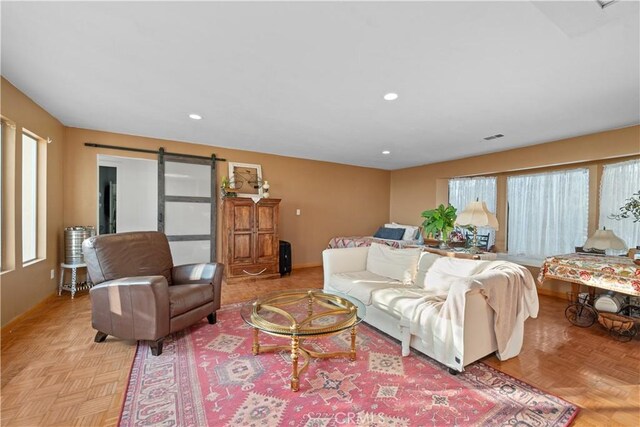 living room with a barn door and light parquet flooring