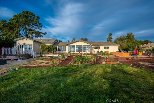 view of front of house with a front lawn and a sunroom