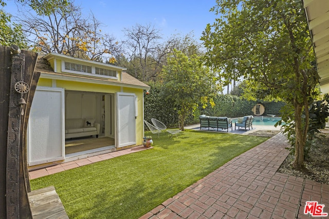 view of yard with a patio area, an outdoor hangout area, and an outdoor structure