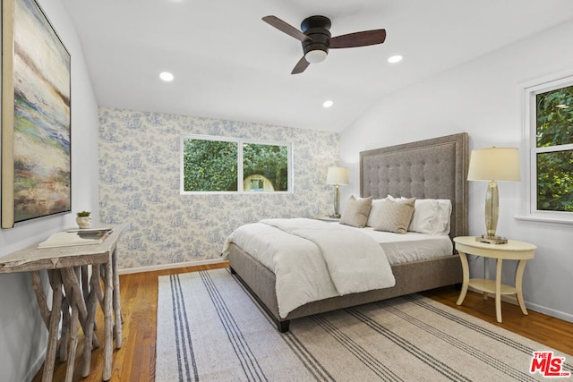 bedroom with ceiling fan, wood-type flooring, and multiple windows