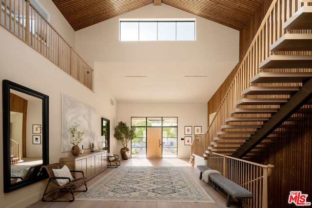 entrance foyer featuring light hardwood / wood-style flooring, high vaulted ceiling, and wooden ceiling