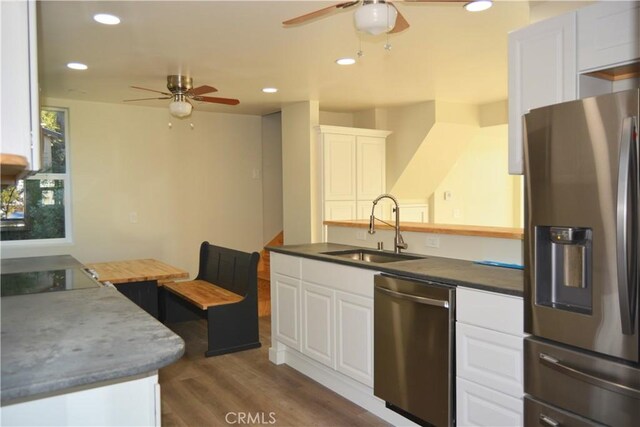 kitchen featuring light wood-type flooring, appliances with stainless steel finishes, white cabinets, and sink