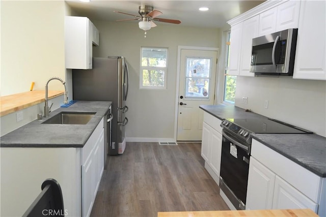 kitchen with appliances with stainless steel finishes, white cabinets, and sink