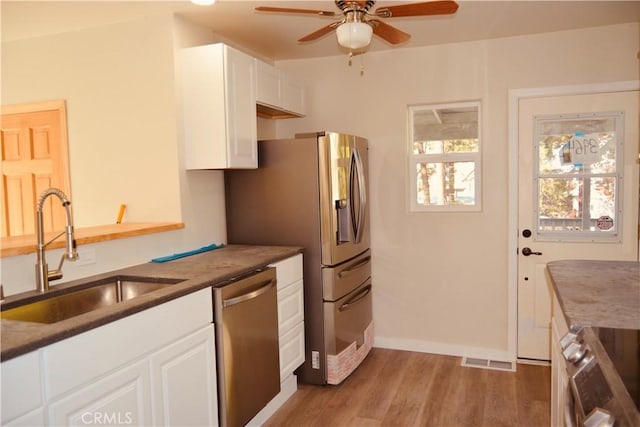 kitchen with dishwasher, stove, sink, light hardwood / wood-style flooring, and white cabinets